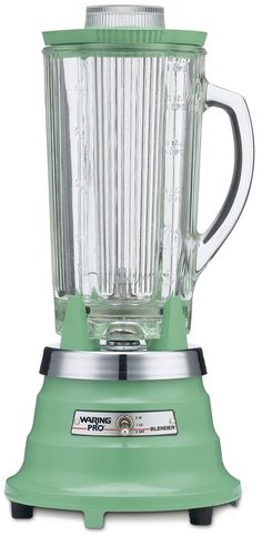 a green blender sitting on top of a white table