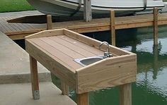 a boat docked at a dock with a sink in the center and another boat behind it