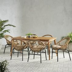 an outdoor table with chairs and potted plants