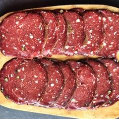 several slices of salami sitting on top of a cutting board