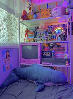 a bed with a stuffed animal on top of it in front of a tv set