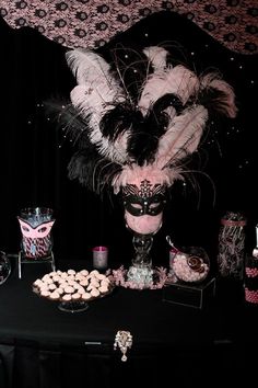 a masquerade themed party with pink and black desserts, cupcakes, and candies