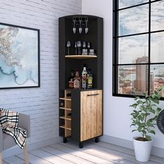 a black and wood cabinet with wine glasses on it next to a potted plant