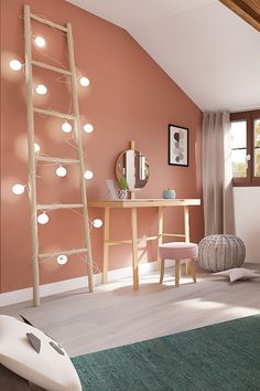 a room with pink walls and white lights on the wall, along with a ladder