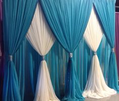 blue and white drapes are hanging on the wall