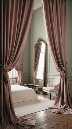 a bedroom with pink drapes on the windows and a white bed in front of a mirror