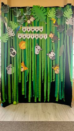 a jungle theme is displayed in front of a wall with green leaves and animals on it