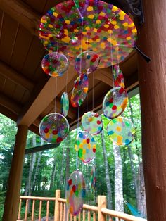 some bubbles are hanging from a wooden pole in front of a porch with wood railings