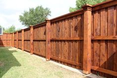 a wooden fence is next to a grassy area