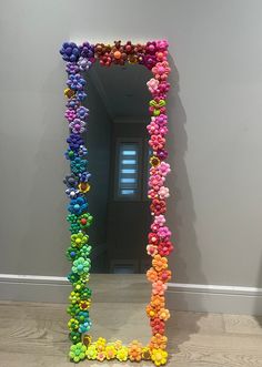 there is a mirror made out of pom - poms on the floor in front of a wall