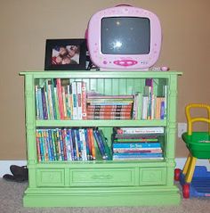 there is a green bookcase with books on it and a tv in the corner