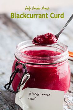 a jar filled with blueberry curd on top of a wooden table