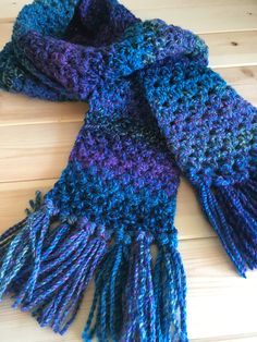 a blue and purple scarf laying on top of a wooden floor