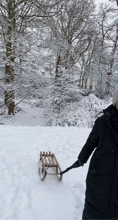 a woman is pulling a sled through the snow