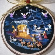 an ornament hanging from the side of a wall with nativity scene on it