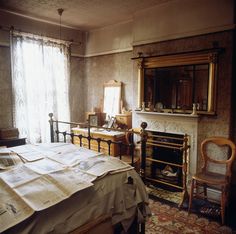 an old fashioned bedroom with a bed and fireplace