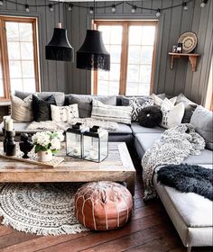 a living room filled with lots of furniture next to two windows and a rug on the floor