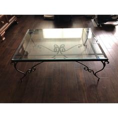 a glass and metal coffee table on a wooden floor