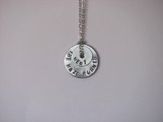 a silver necklace with words on it that says, the adventure zone is here and there is