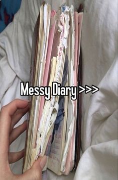 someone is holding an open book with the words messy diary on it in front of them