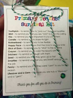 a hand holding up a paper card with writing on it that says, primary teacher survival kit