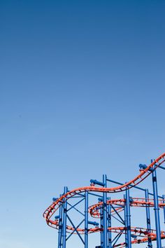 an orange and blue roller coaster against a blue sky