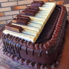 a chocolate cake with white and brown icing on it's sides, topped with an electronic keyboard