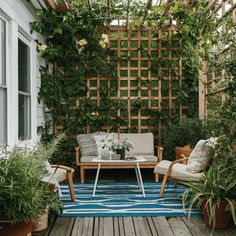 an outdoor living area with plants and furniture on the deck, surrounded by wooden trelliss