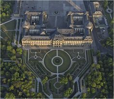 an aerial view of a large building in the middle of a park with lots of trees