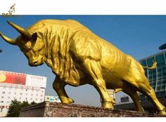 a golden bull statue in front of a building