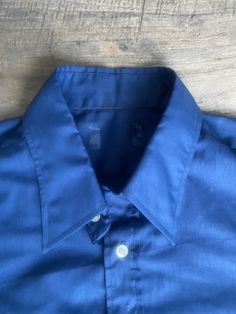 "This deep blue, genuine 1970s vintage, short sleeve, butterfly collared shirt is in excellent vintage condition. SIZE: Pit to Pit: 25\" Collar to hem: 31\" Sleeves: 11\" The tag does not have a size. Check the measurements. I would say it fits like a roomy XL The male mannequin would be 5'10\" 170 lbs. ITEM 125" Classic Indigo Shirt For Summer, Blue Cotton Camp Shirt With Spread Collar, Navy Collared Short Sleeve Cotton Shirt, Navy Collared Cotton Short Sleeve Shirt, Navy Cotton Collared Short Sleeve Shirt, Blue Collared Cotton Camp Shirt, Classic Navy Cotton Short Sleeve Shirt, Fitted Solid Shirt With Polo Collar, Blue Cotton Collared Camp Shirt