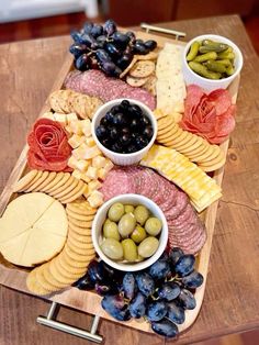 an assortment of cheeses, crackers and olives on a platter