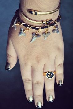 a woman's hand with two different bracelets and rings on her left wrist