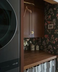 a washer and dryer in a room with floral wallpaper on the walls