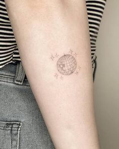 a woman's arm with a small globe tattoo on the left side of her arm