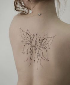 a woman's back with a flower tattoo on it