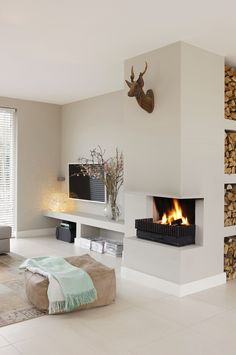 a living room filled with furniture and a fire place next to a wall mounted tv