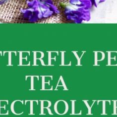 purple flowers sitting on top of a table next to a green sign that says, butterfly pea tea electrolyte