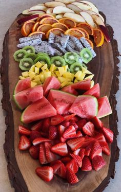 sliced up fruit arranged on a wooden platter