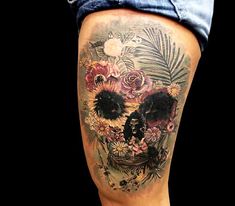 a woman's thigh with a skull and flowers on it