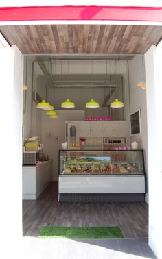 the inside of a food stand with lights hanging from it's ceiling and various foods on display