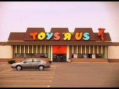 a toy store with cars parked in the parking lot