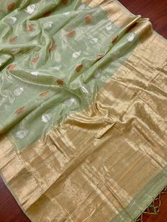 Beautiful Pista Green color Linen Soft Silk Saree with Weaved Buttas all over. Saree is super light weight and very Stable. Copper and Sliver Buttas on the body of the Saree while the Border and Pallu is Matt Gold. Please note - Since the material is tissue, it might looks lighter in shade in sunlight and darker in room-light specially in yellow light. Item : SareeColor : Pista GreenBase Fabric : Linen Soft Tissue Silk Blouse piece : YesBlouse material : Linen Soft Tissue Silk Transparent (Yes/N Pista Green Cotton Silk Dupatta For Festivals, Pista Green Slub Silk Traditional Wear With Zari Weaving, Pista Green Chanderi Traditional Wear For Festivals, Festival Chanderi Traditional Wear In Pista Green, Pista Green Self Design Chanderi Blouse Piece, Pista Green Self-design Chanderi Blouse Piece, Pista Green Chanderi Blouse Piece With Self Design, Festive Pista Green Handloom Blouse Piece, Pista Green Tissue Silk Traditional Wear For Festivals