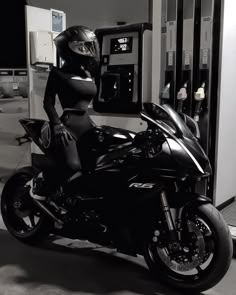 a woman dressed in black is sitting on a motorcycle