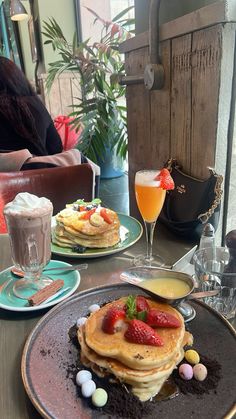 pancakes with strawberries and eggs on a table