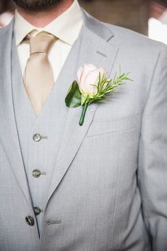 a man in a suit with a boutonniere and flower on his lapel