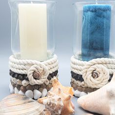 two vases with seashells and candles in them