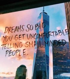 the reflection of a building in a window with writing on it that says dreams so big you get uncomfortableable telling small minds people