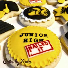 decorated cookies with the words junior high next to each other on a white tablecloth