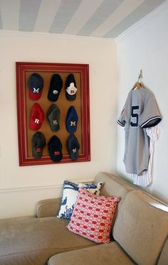 a baseball jersey hangs on the wall next to a couch with pillows and throw pillows